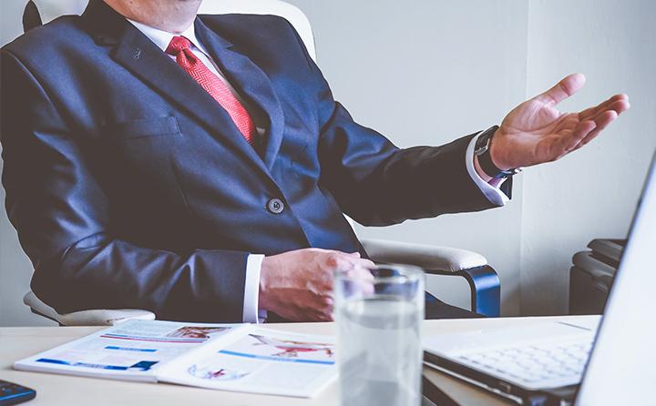 Photo of man in suit behind a desk